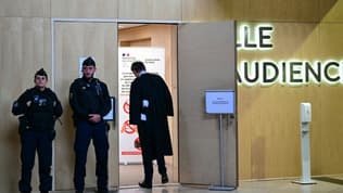 Des gendarmes et un avocat devant l'entrée de la salle d'audience à l'ouverture du procès en appel de l'attentat de Nice, le 22 avril 2024 à Paris