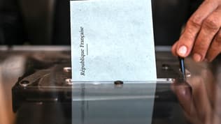 Un bulletin est glissée dans une urne, au premier tour de l'élection présidentielle, dimanche 10 avril 2022 à Lyon
