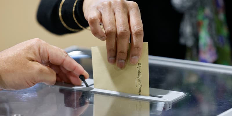 Une électrice glisse son bulletin dans une urne du Touquet pour le premier tour des législatives, le 12 juin 2022